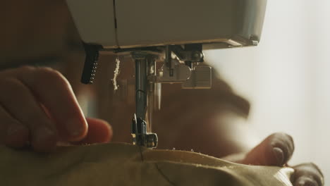 A-woman-sews-bed-linen-on-a-sewing-machine,-close-up.