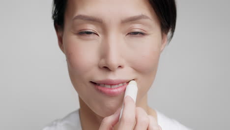 mujer aplicando bálsamo labial