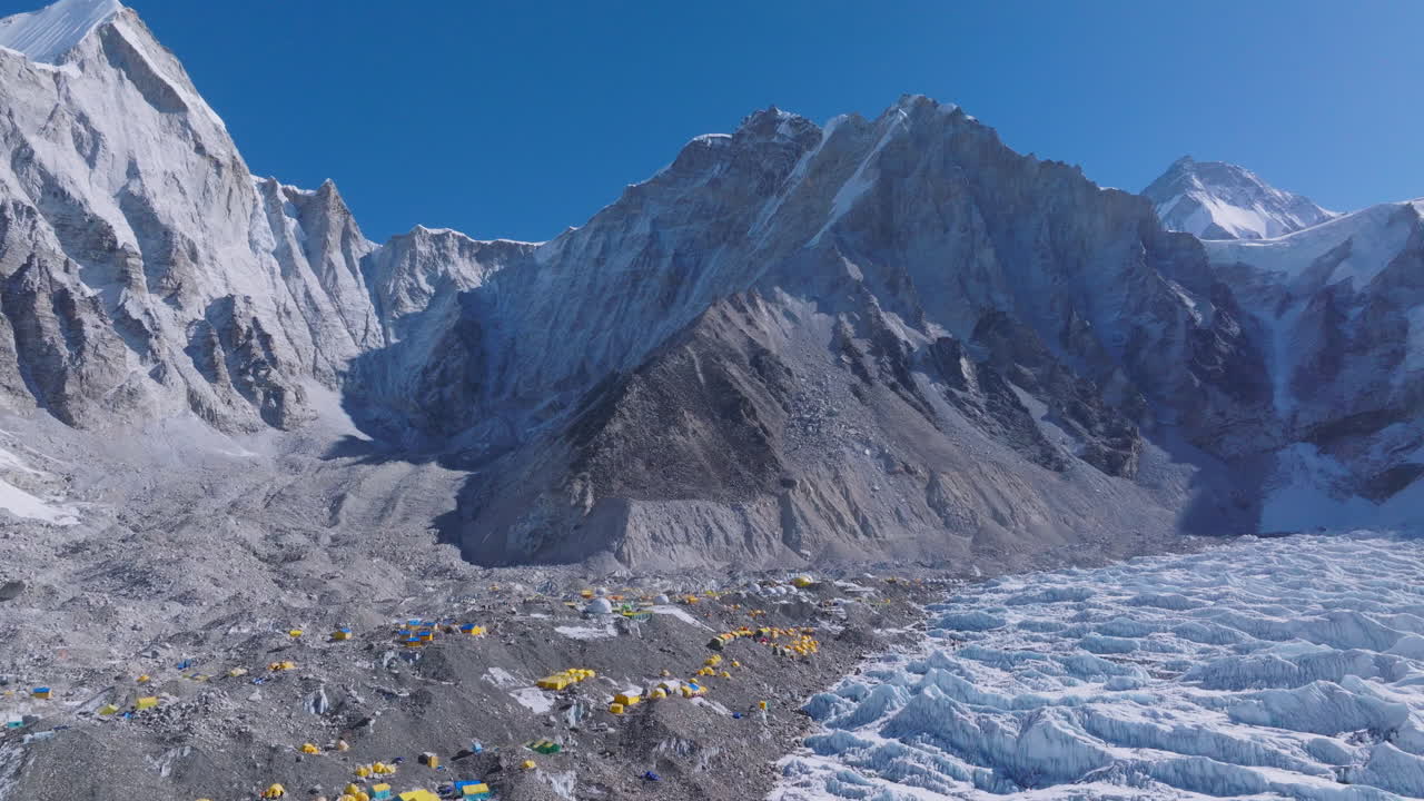 Aerial view of Everest Base Camp with snow peaks, climber tents, summit start point, and adventure tourism in Nepal, exploration of landscape mountain ranges, clear blue sky, dense snow land