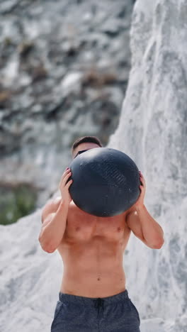 man exercising medicine ball outdoors. healthy young man exercising with medicine ball vertical video