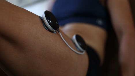 imágenes de primer plano de almohadillas de masaje de electrovibración que se utilizan en las piernas de un atleta