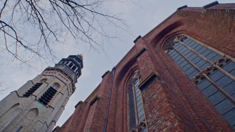 traditional european dutch style cathedral chapel tower architecture building in netherlands with authentic art design and sightseeing walkthrough and low angle viewpoint