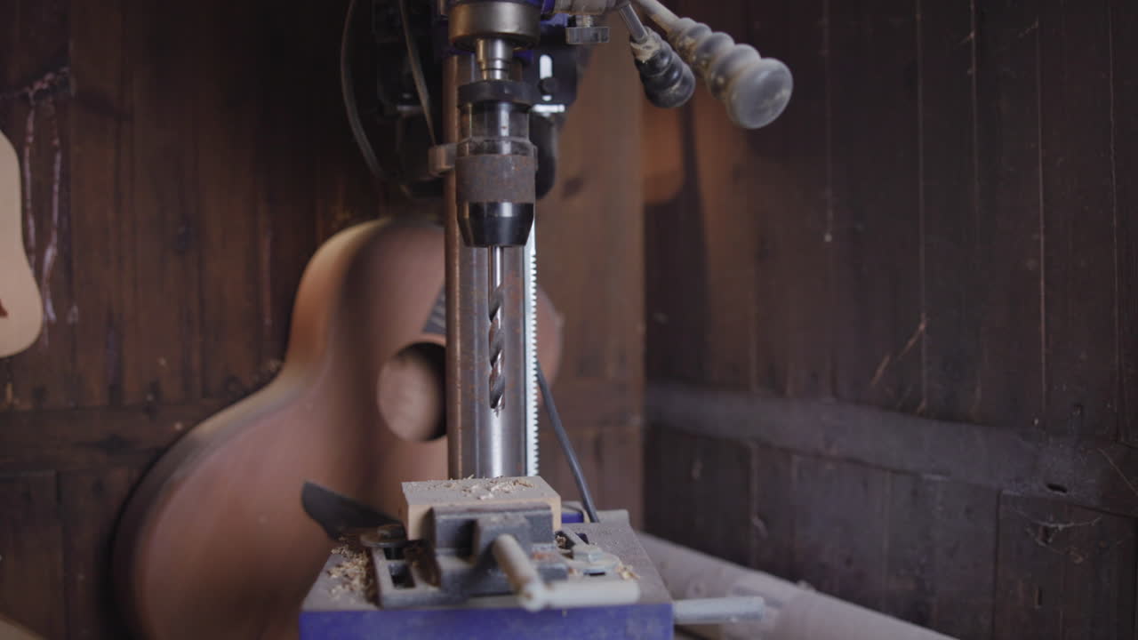 Trapano a colonna in un laboratorio di lavorazione del legno con una chitarra
