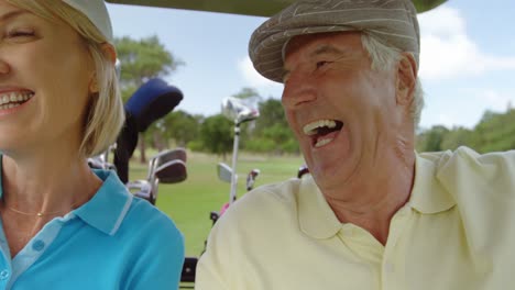 two golfers driving in their golf buggy