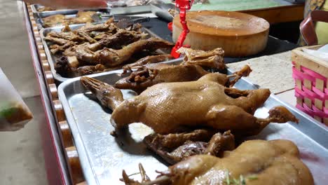 close-up footage of street food vendor displaying chinese stewed duck on stainless tray