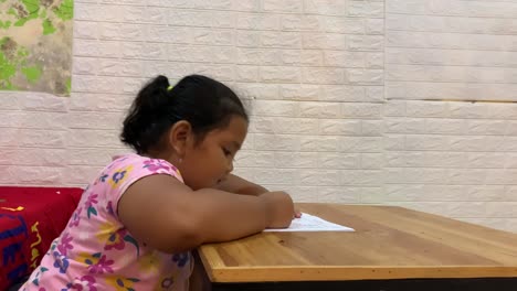 Seitenansicht-Eines-Asiatischen-Kleinen-Mädchens,-Das-Zu-Hause-Auf-Dem-Tisch-Lernt