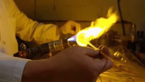 Mid-section-of-male-worker-blowing-glass-in-glass-factory-4k