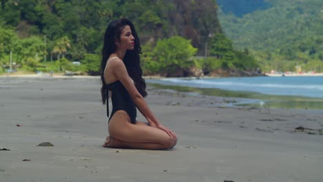 a young hispanic girl wades through the turquoise waters of a tropical caribbean beach in her bikini.