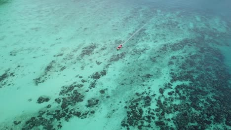 Vista-Aérea-Abstracta-En-El-Tradicional-Barco-De-Cola-Larga-Tailandés-Navegando-Sobre-Arrecifes-De-Coral,-Archipiélago-De-La-Isla-Phi-Phi,-Tailandia