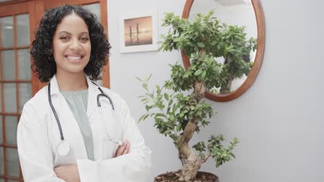 portrait of biracial female doctor wearing lab coat and stethoscope, copy space, slow motion