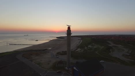 aerial: the pier, beach and lighthouse during sunset near the village westkapelle, the netherlands