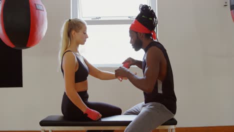 trainer wearing hand wrap to female boxer 4k