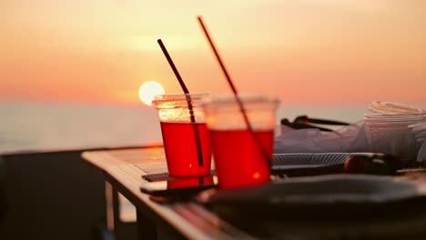 plastic cups with drinks on yacht, during sunset in baltic sea, liepāja, latvia