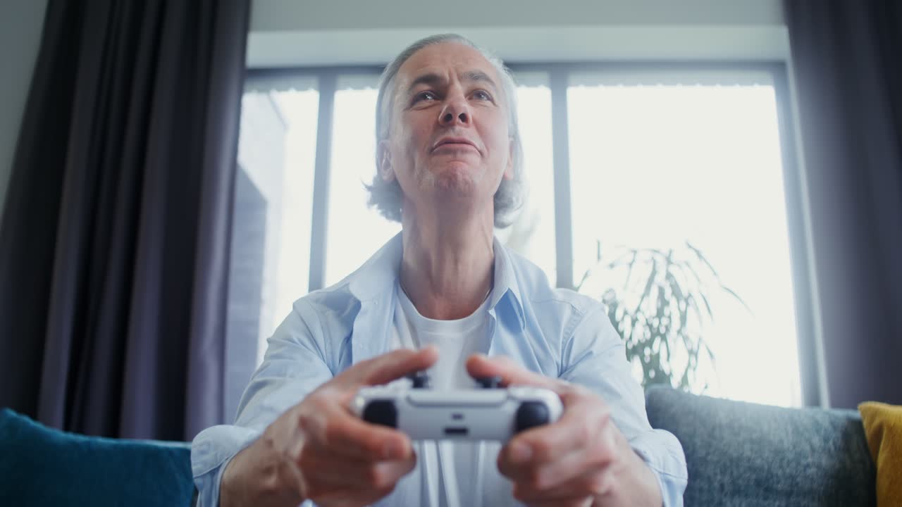 Mature man enjoying video games at home