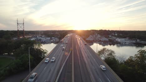 drone shot tracking forward over interstate median at golden hour with moderate traffic