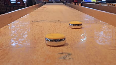 people playing shuffleboard viewed from close to table at end