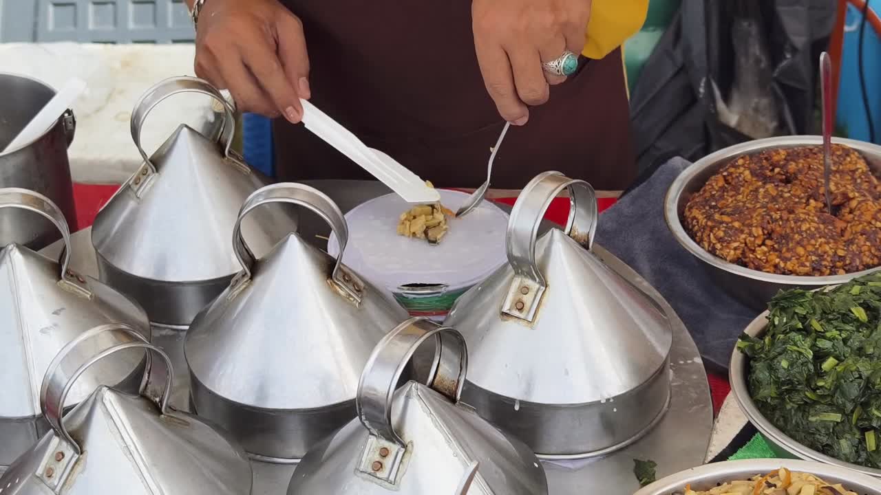 거리 음식 판매자 가 증기 된 음식 을 준비 하고 있다