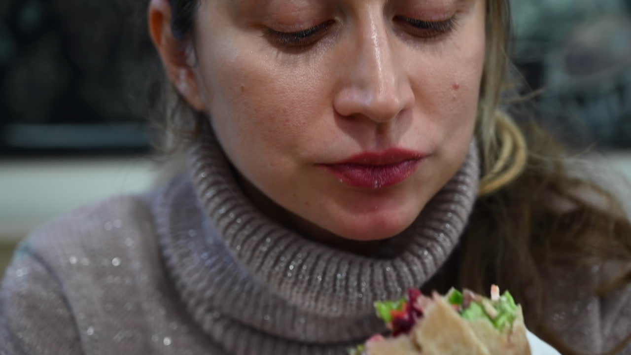 Close up of a woman eating a vegetable wrap