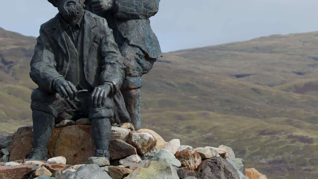 Bronze statue of two men, outdoor memorial, wide shot, natural daylight, slow camera pan