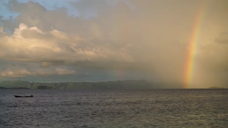 un arco iris en el fondo mientras un pequeño bote de madera tradicional está sacando el marco