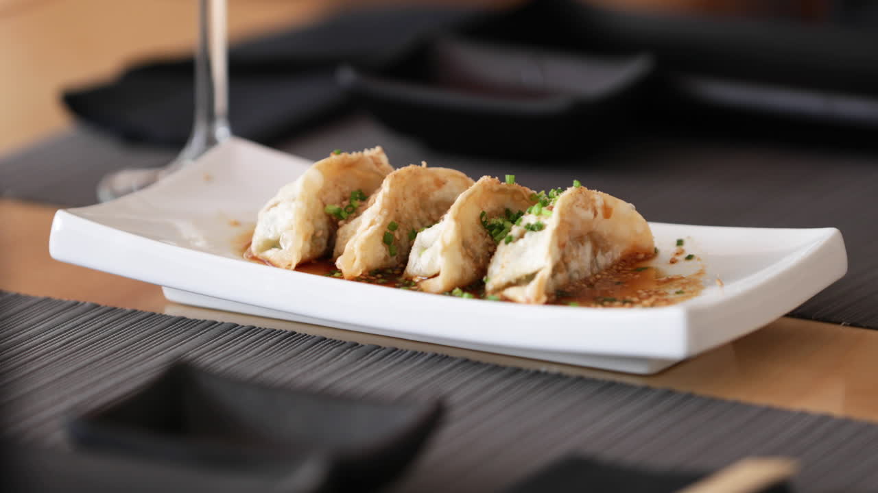 Plate Of Gyoza Dumplings Served On The Table. - slow motion - panning shot