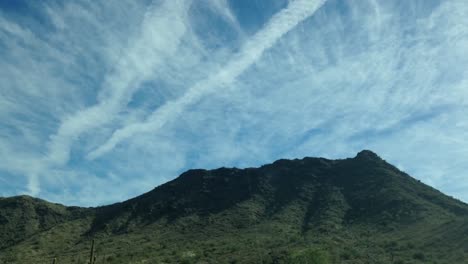 time lapse shot of clouds moving over rocky mountains during sunnny time