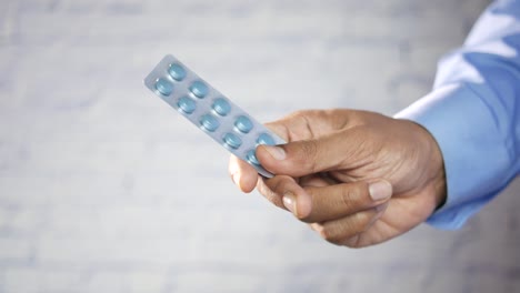 person holding a blister pack of pills