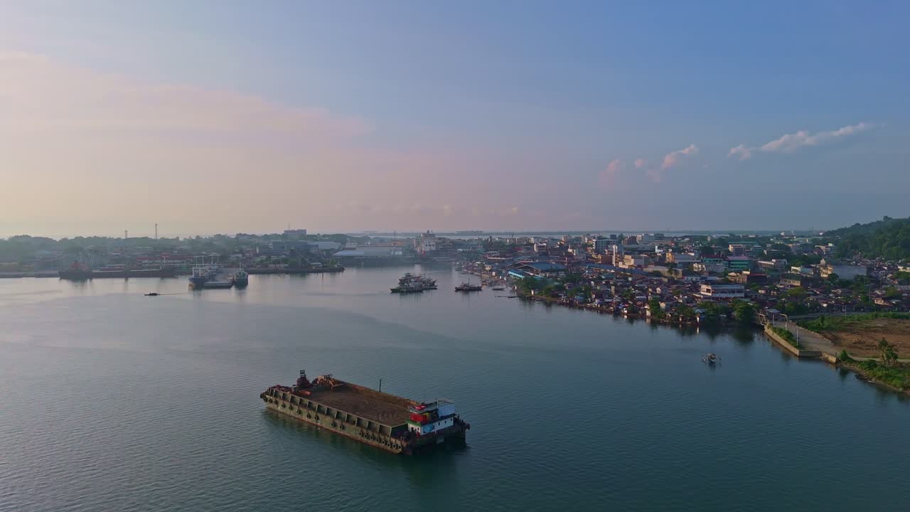 Barge and boats in the San Juanico Strait at Tacloban Harbor at sunrise, aerial view