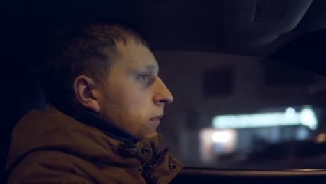 Young-man-driving-car-at-night.-View-from-the-inside.