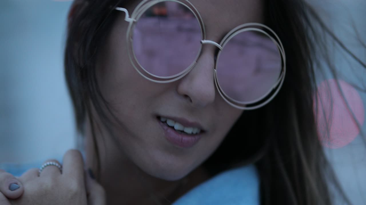 joven posando con grandes gafas de sol redondas y divertidas