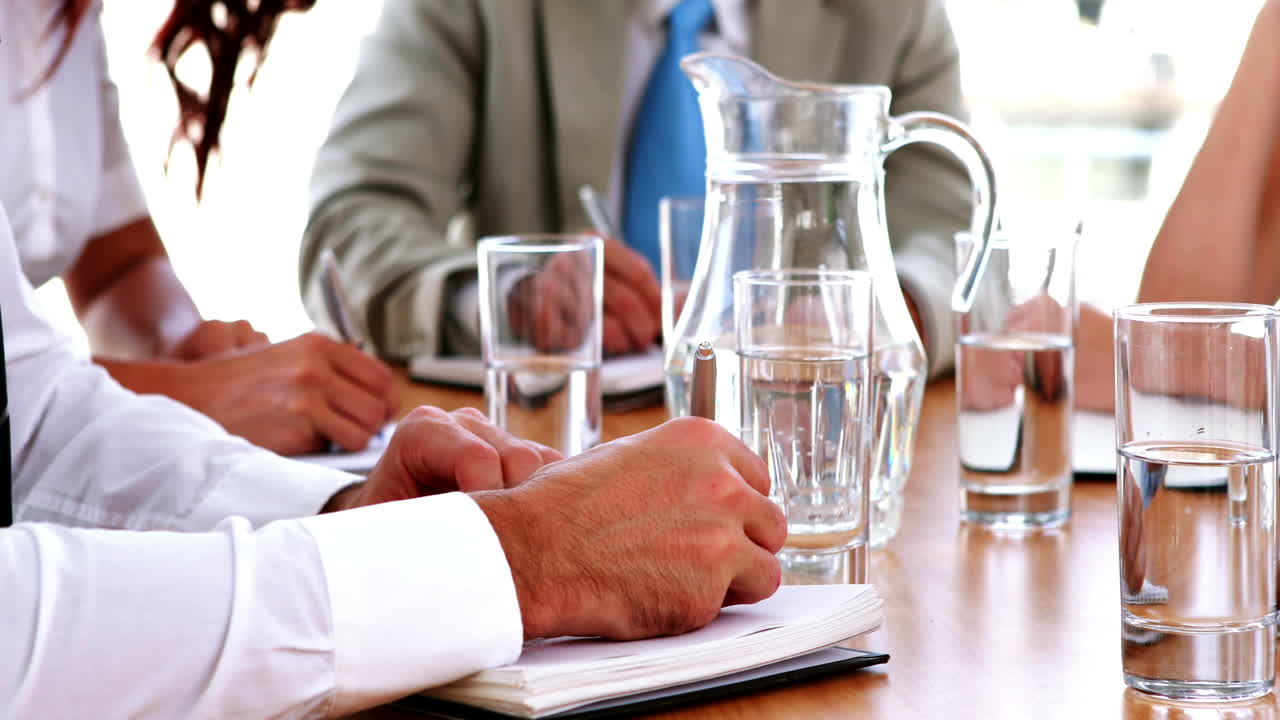 ビジネスマンが会議でメモを取っている