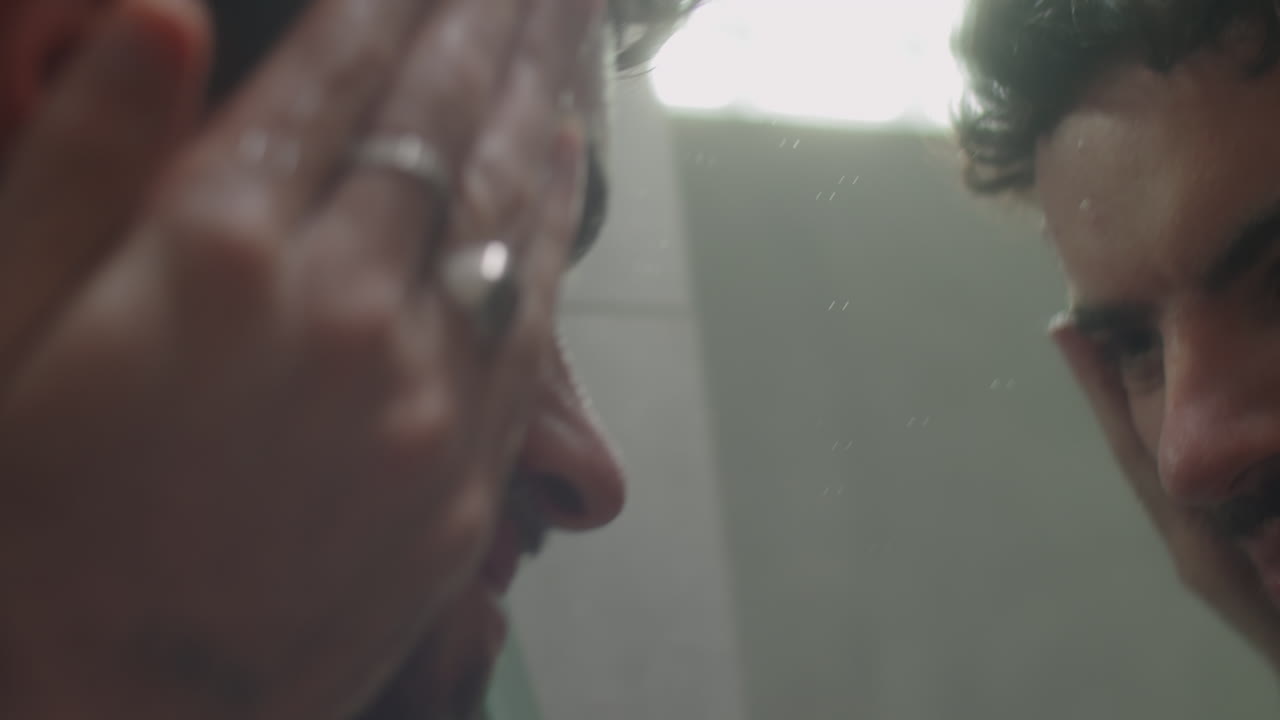 Man Washing Face in front of Bathroom Mirror