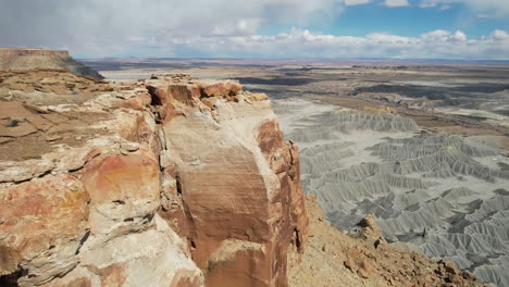 Drone-Shot-of-Woman-Walking-on-The-Edge-of-Cliff-Above-Deep-Desert-Canyon-and-Abyss