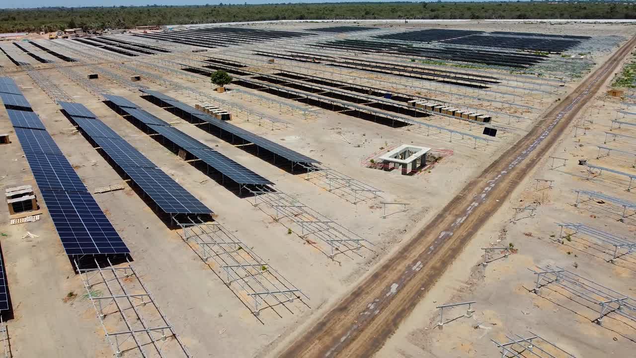 Flying over photovoltaic power plant with solar panels under construction in Jambur, Gambia