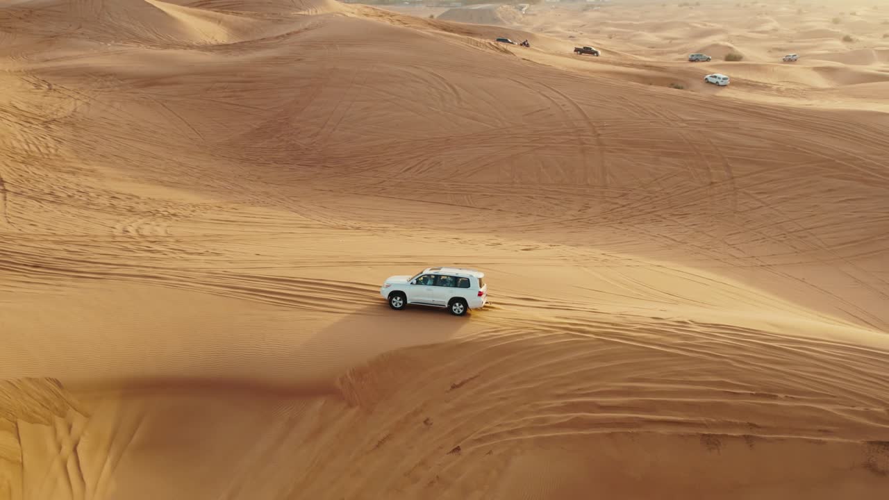 vista aérea de un vehículo 4x4 conduciendo a través de las dunas del desierto