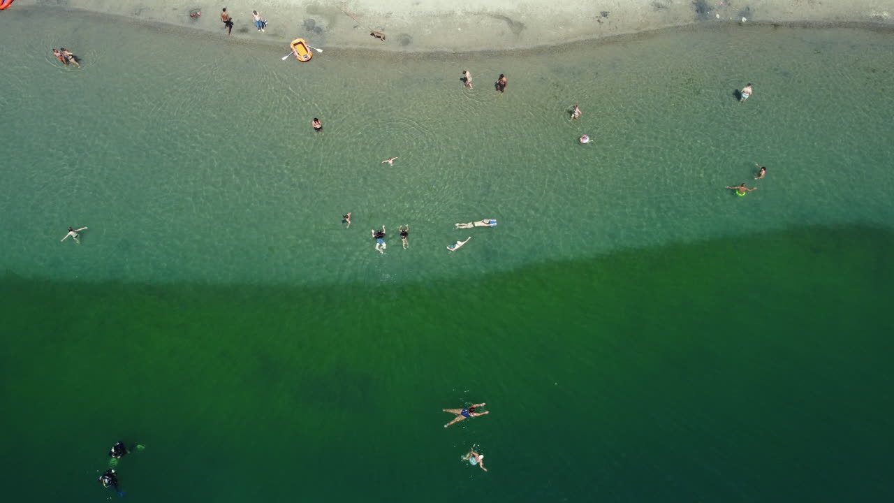 Aerial View of People Relaxing and Swimming at the Beach