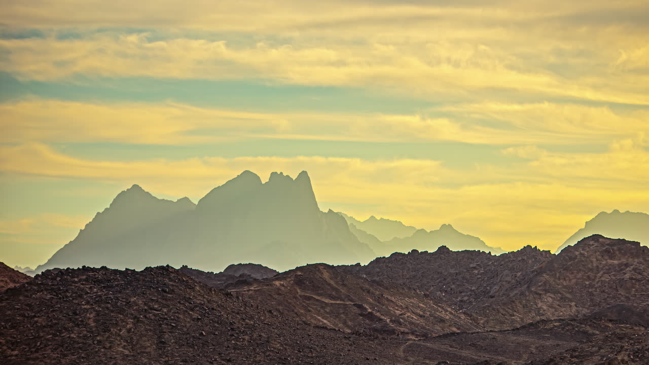 lapso de tiempo de nubes moviéndose sobre el paisaje desértico con la silueta de las montañas en segundo plano
