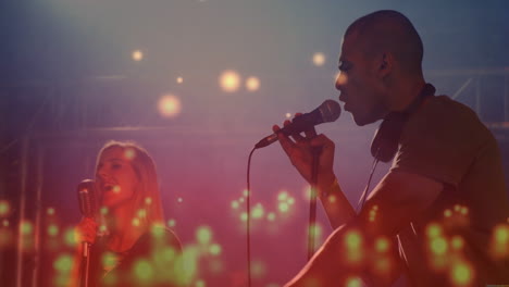 duo performing on music stage under colored spotlights, with animated equalizers around microphones