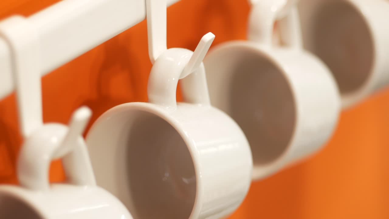 오렌지색 벽에 매달린  컵