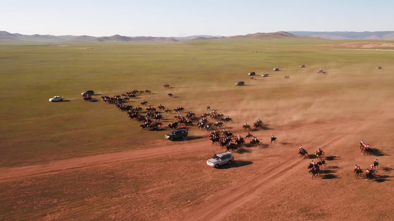 un grupo de jinetes mongoles entrenando para una carrera de caballos en mongolia llamada naadaam