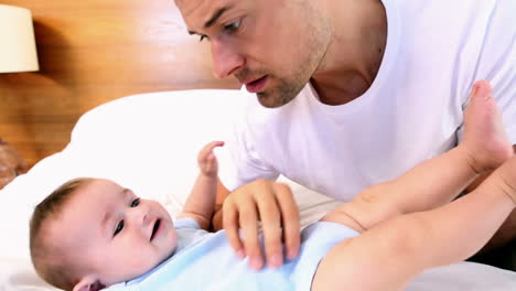 Happy-father-tickling-his-baby-son-on-bed