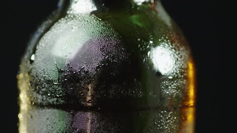 una botella de vidrio con gotitas de condensado de cerveza fría apareció en la superficie de un video de 4k y 10 bits