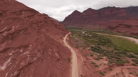 Vista-Aérea-Panorámica-De-Un-Camino-Sinuoso-A-Través-De-Los-Paisajes-De-Rocas-Rojas-De-La-Ruta-68,-Quebrada-De-Las-Conchas.