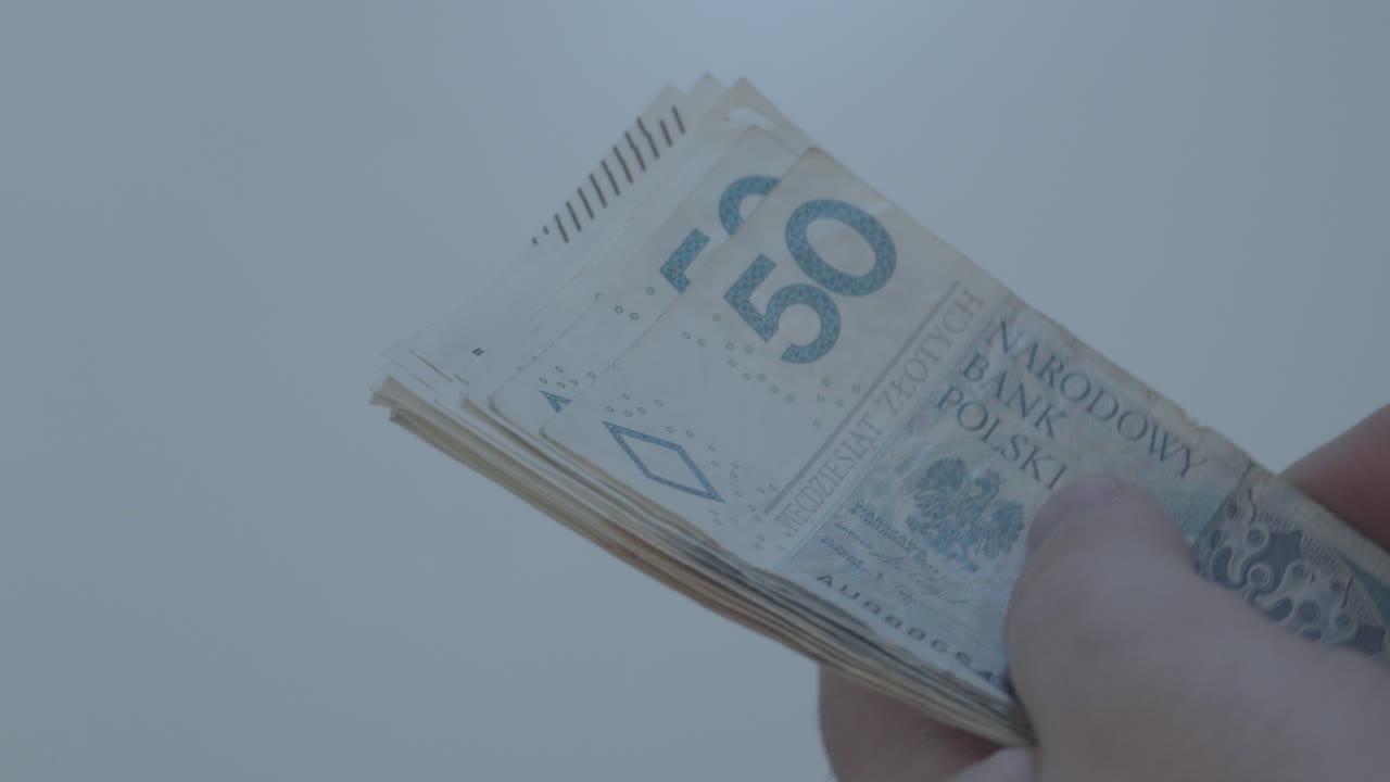 mano de hombre con billetes de 50 100 200 en zloty polaco