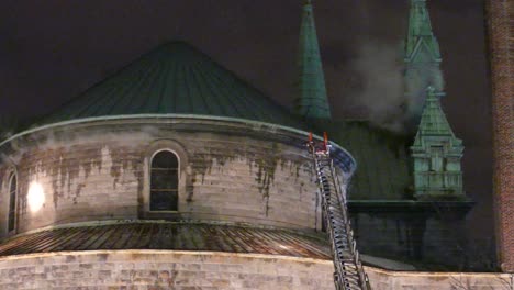 slow pan shot of historic religious building with smoke from fire