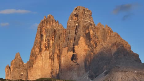 the towering drei zinnen peaks glow during golden hour in the italian alps