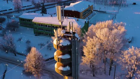 cell antenna on old tower in small rural town, snowing