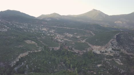 Clip-Aéreo-En-Movimiento-Lento-Tomado-Por-Un-Dron-De-Un-Pequeño-Pueblo-En-Geyikbayiri-En-Turquía-En-Medio-Del-Paisaje-Montañoso-Rocoso