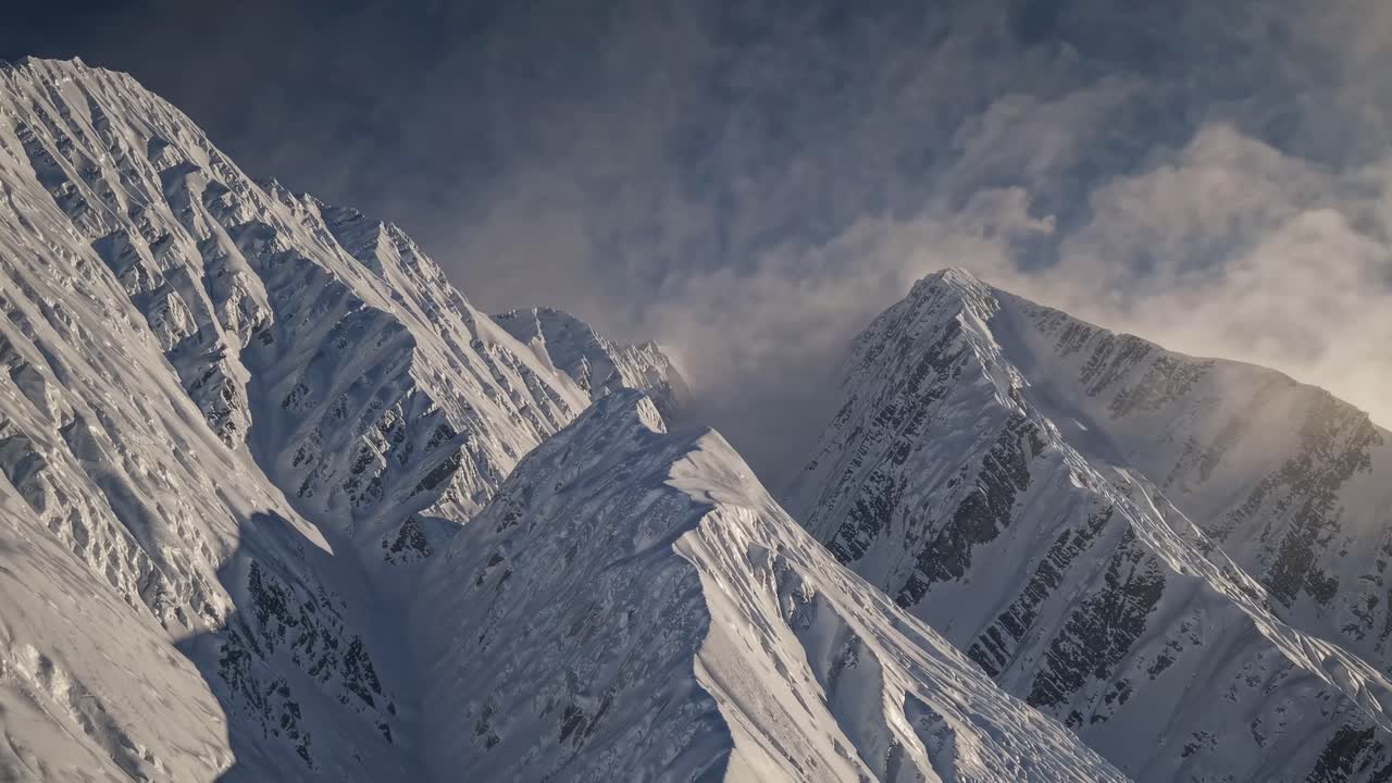 Aerial video of rugged snow-covered mountains, capturing dramatic peaks and ridges