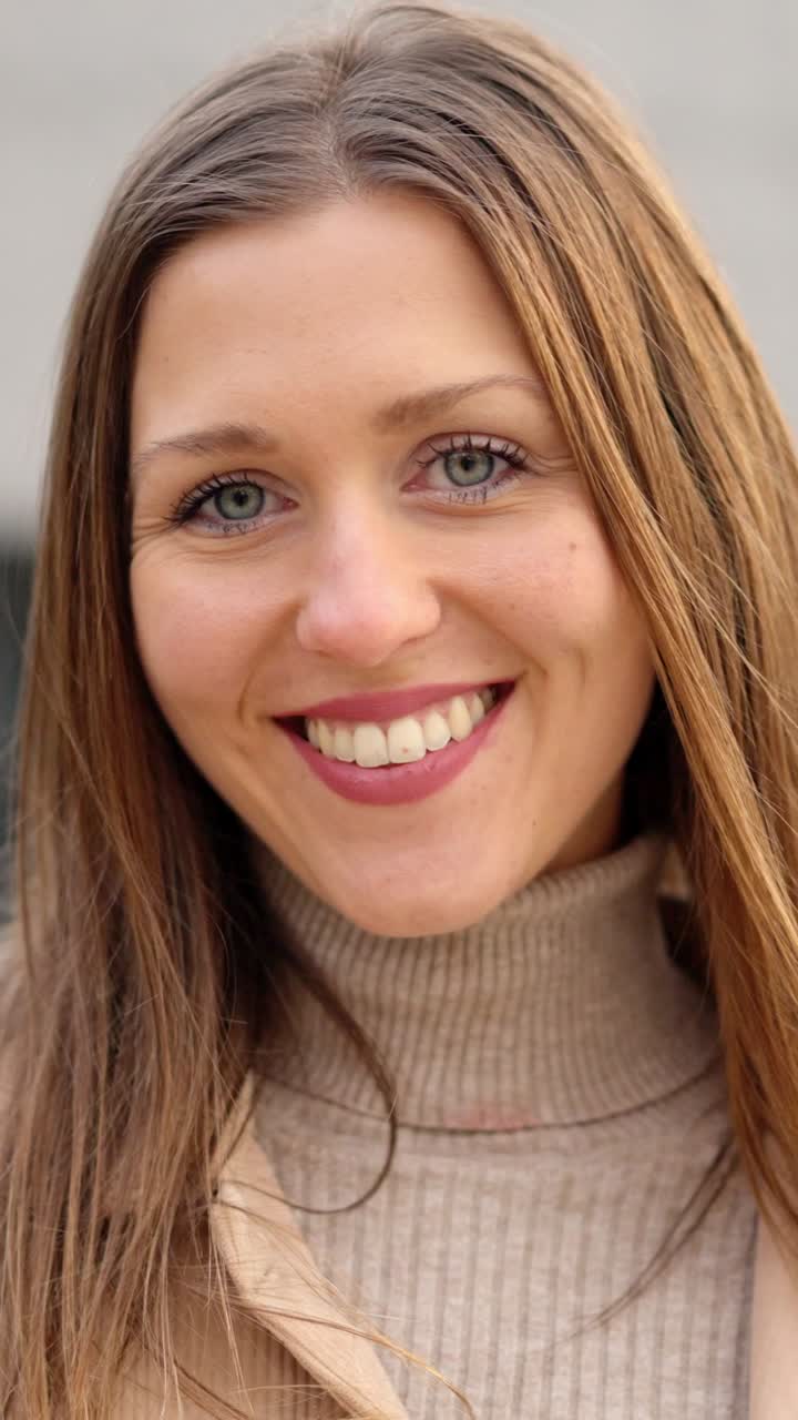 Young female student smiling at camera outdoors